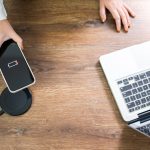 Ładowanie baterii telefonu komórkowego za pomocą urządzenia do ładowania bezprzewodowego w stole Ładowanie smartfonu na poduszce do ładowania Telefon komórkowy w pobliżu ładowarki bezprzewodowej Nowoczesna technologia stylu życia