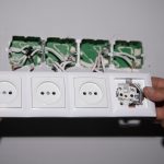 Elektryk instalujący nowe wtyczki elektryczne