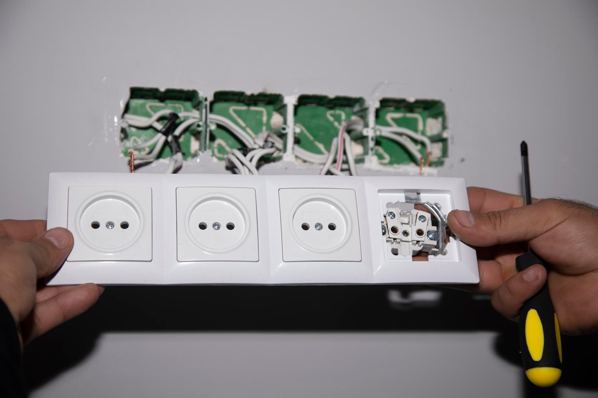 Elektryk instalujący nowe wtyczki elektryczne