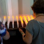 Ludzie modlą się przed świecami w kościele na cmentarzu Campo Santo w Święto Zmarłych