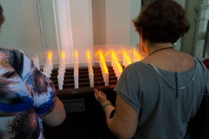 Ludzie modlą się przed świecami w kościele na cmentarzu Campo Santo w Święto Zmarłych