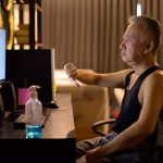 Zaakcentowany dojrzały Japończyk używa komputer i daje kciukom w dół w domu