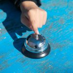 Kobieta dzwoni do dzwonka na stole