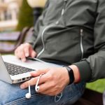 Mężczyzna pracuje na laptopie outside z słuchawkami