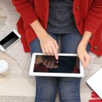 Młoda kobieta pracująca na tablecie w domu z góry