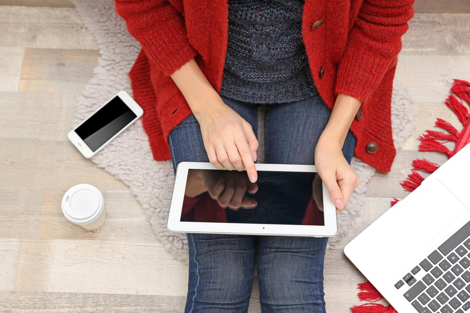 Młoda kobieta pracująca na tablecie w domu z góry