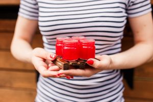 Dziewczyna trzyma drewnianą deskę z 4 czerwonymi strzałami pije