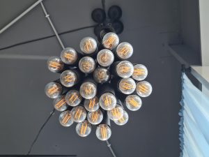 Wiele wiszących żarówek w stosie na suficie