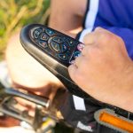 Widok z góry ręki człowieka używającego joysticka elektrycznego wózka inwalidzkiego