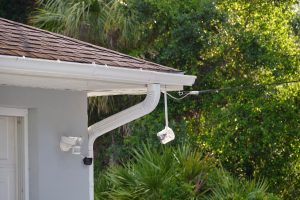 Czujnik ruchu z wykrywaczem światła zamontowany na zewnętrznej ścianie prywatnego domu jako część systemu bezpieczeństwa