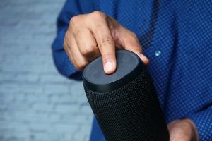 ręka mężczyzny za pomocą inteligentnego głośnika z bliska