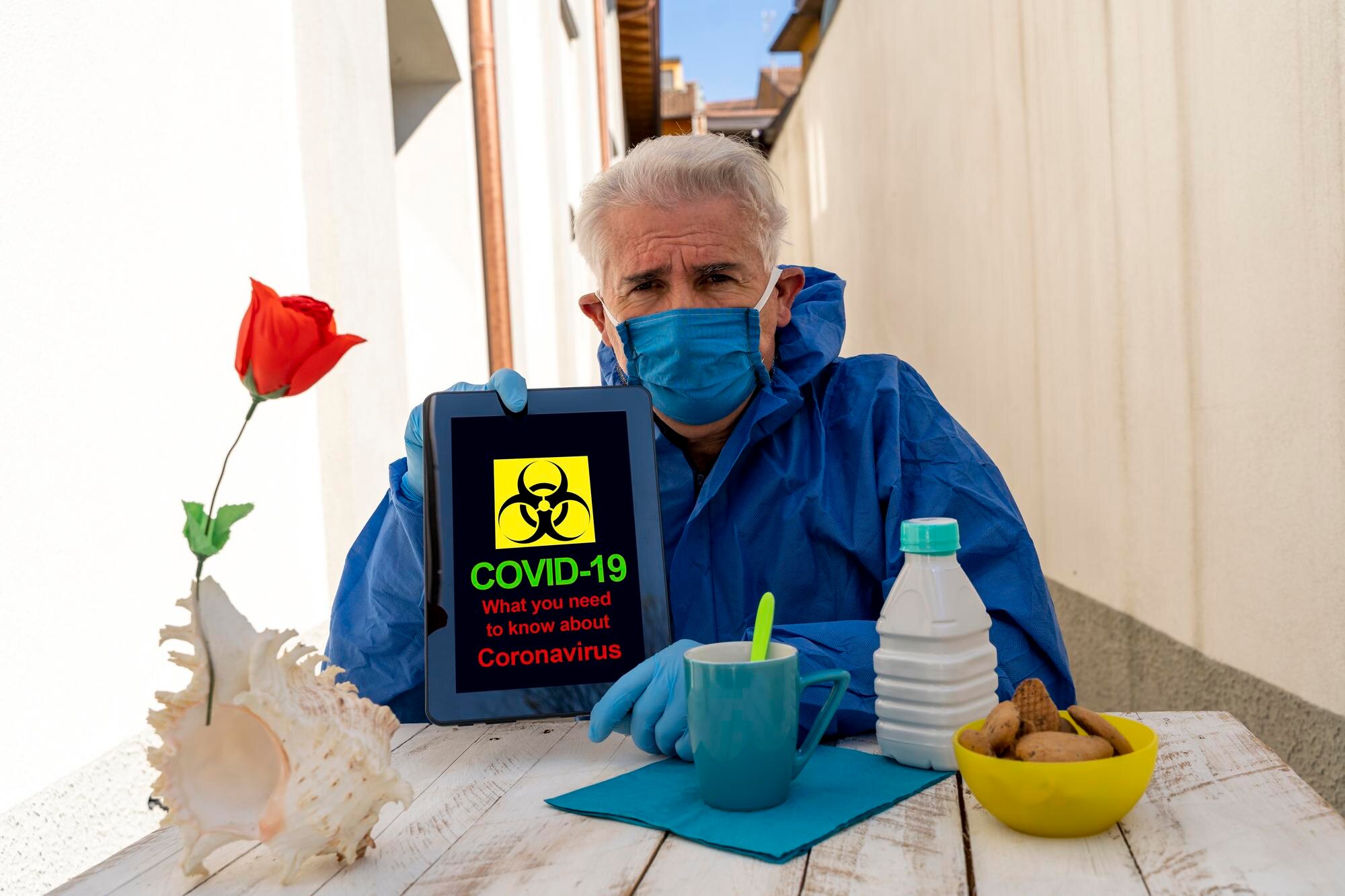 Portret mężczyzny w odzieży ochronnej pokazujący tablet cyfrowy siedzącego przy stole