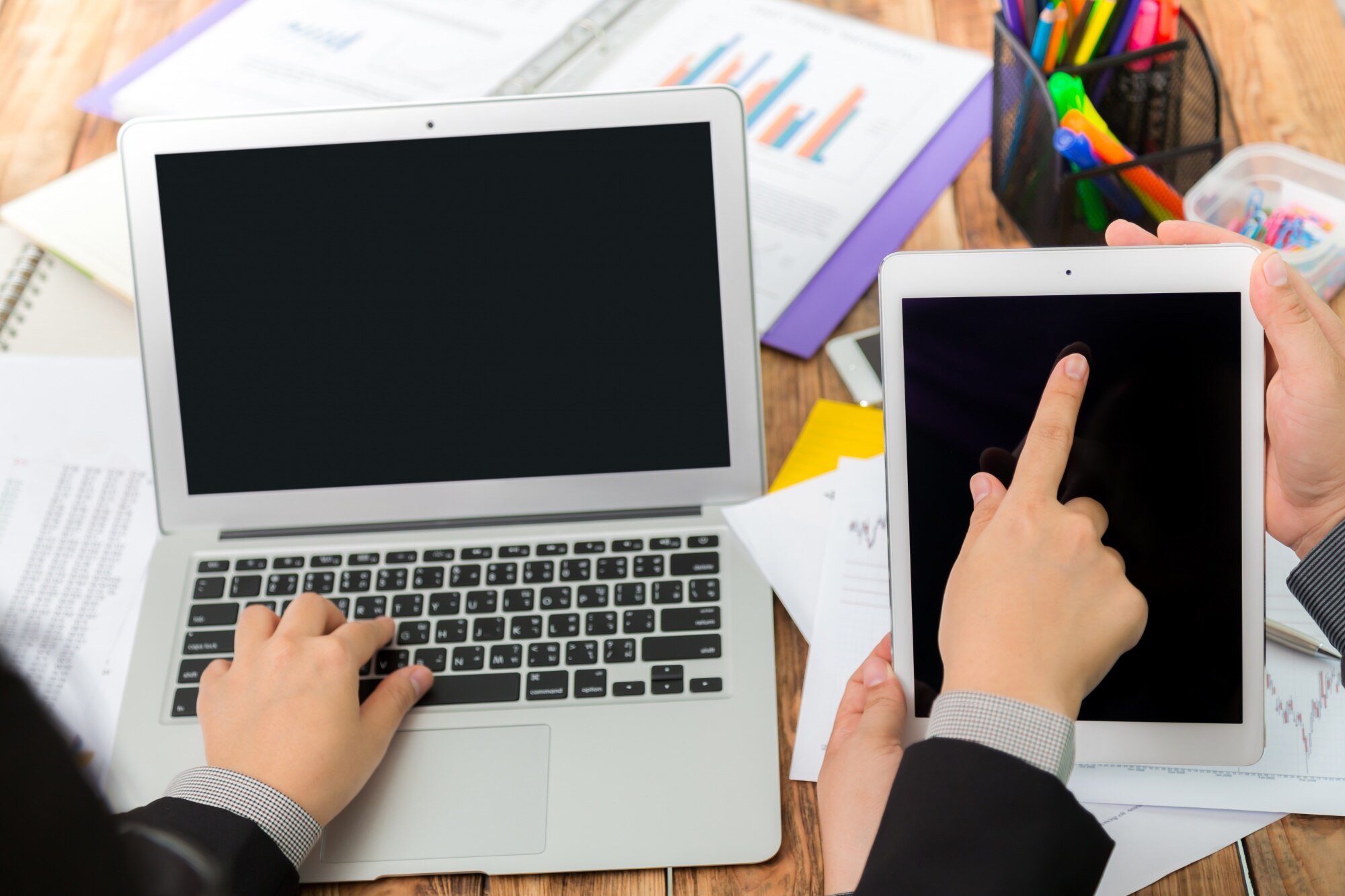 Biznesmen pisania na laptopie i wskazując tabletkę