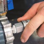 Przycięta ręka hydraulika przymocowującego rurę do metalu