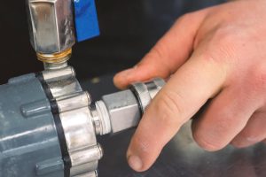 Przycięta ręka hydraulika przymocowującego rurę do metalu